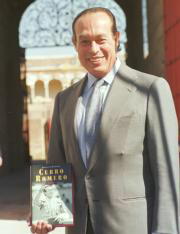 Curro Romero, con el libro, ante la Puerta del Principe